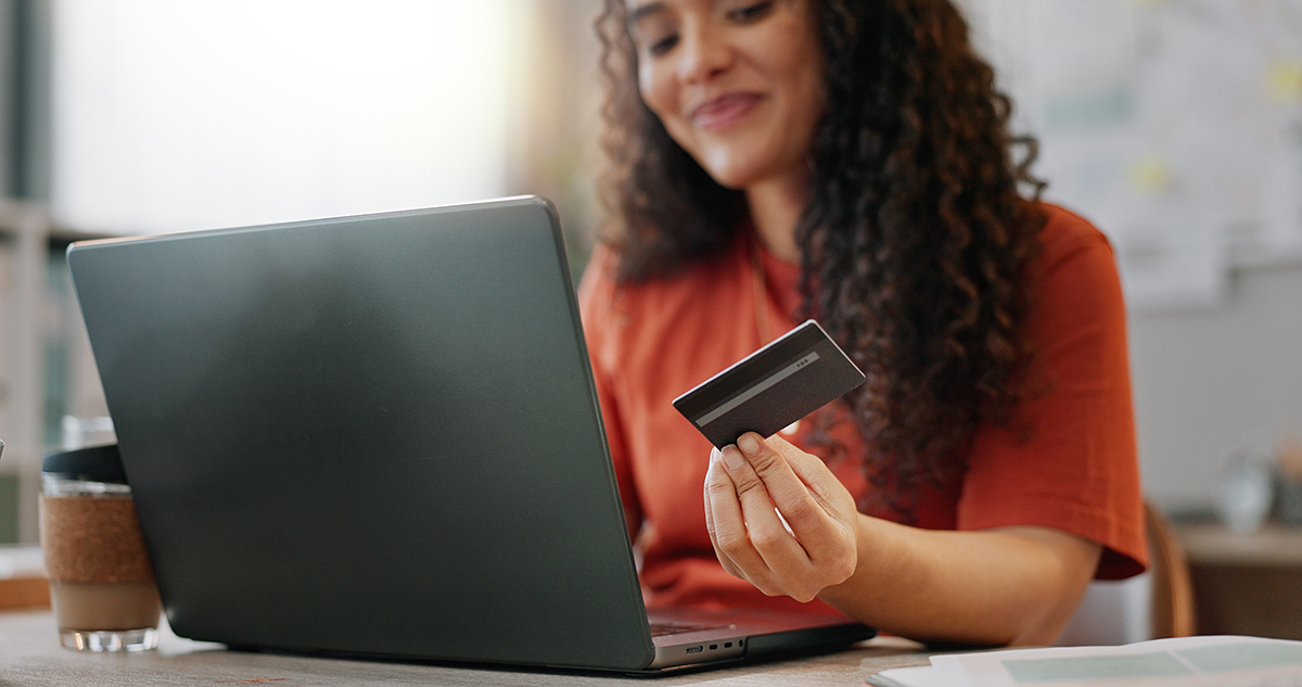 A woman on her computer entering her credit card to make a purchase.