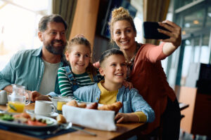A family of 4 taking a selfie photo.